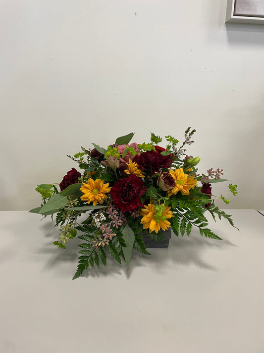 Join the Oct 6 Thanksgiving Small Centrepiece Workshop at 6 PM by Posies Flowers & Fashion Inc.—create a floral centrepiece with yellow daisies, red carnations, pink blooms and greenery in Bancroft, Ontario. Perfect for an autumn-themed class!.