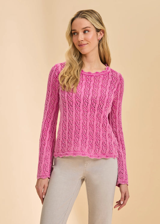 A woman stands against a beige background wearing the French Dressing Jeans Long Sleeve Garment Dye Sweater in Fuschia (1467314) with light beige pants, looking slightly left with a relaxed expression.
