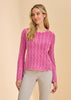 A woman stands against a beige background wearing the French Dressing Jeans Long Sleeve Garment Dye Sweater in Fuschia (1467314) with light beige pants, looking slightly left with a relaxed expression.