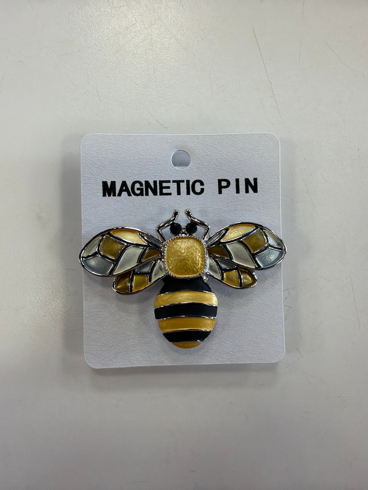 Denise 19 Brooch, a bee-shaped magnetic pin with a yellow and black striped body and translucent stained-glass style wings, mounted on a white “MAGNETIC PIN” display card.