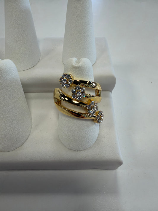 Jenna 86 Ring by Elise accessories, a gold bypass ring on a stretch band featuring three flower-shaped clusters of clear CZ stones.