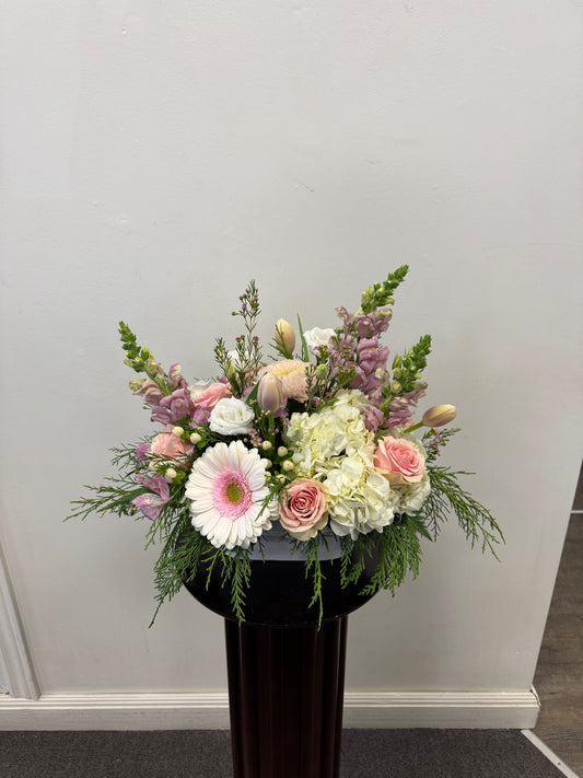 The Soft Elegance Arrangement by Posies Flowers & Fashion features pink gerberas, roses, white hydrangeas, tulips, and greenery in a black vase. Flower availability may vary and substitutions may affect image accuracy.