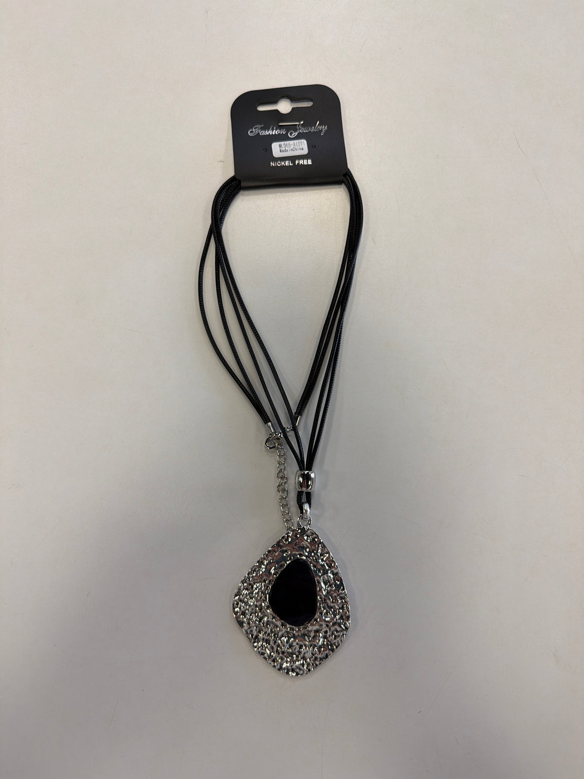 The Elise accessories Sofia 33 necklace features a multi-strand black cord with a large, burnished teardrop pendant and a smooth black center inlay.