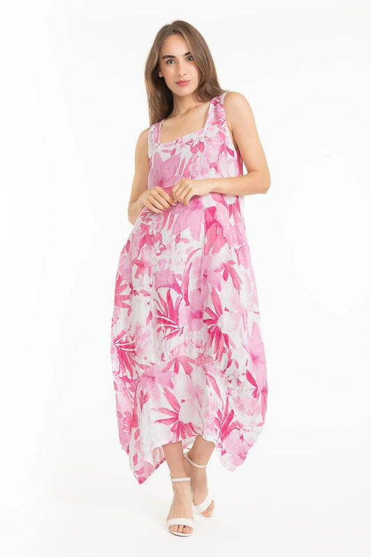 A person in a pink and white floral French Linen Dress TP1613-90 Rosa by LinenLuv stands against a white background. With long hair and white sandals, the loose-fitting, eco-friendly dress flows gracefully below the knees.