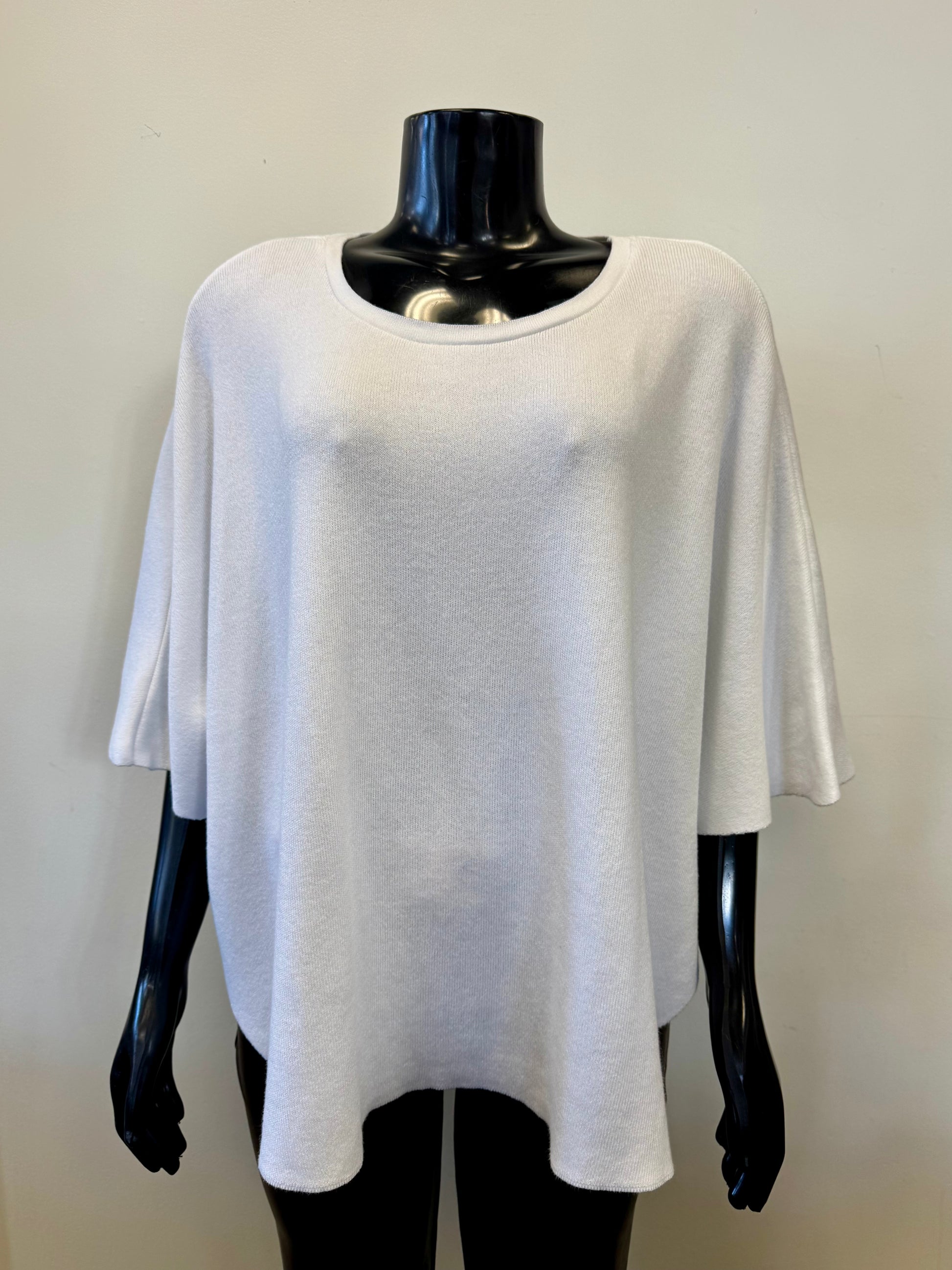 The Lainey Capelet White 22277 by Parkhurst is displayed on a glossy black mannequin against a neutral background, featuring a round neckline and relaxed silhouette for the ideal mix of comfort and style.