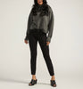 A person stands against a neutral background wearing an oversized gray sweater, JAG's Cassie Mid Rise Slim Straight Ponte Pant in black, and black open-toe heeled mules. Their hands hang relaxed at their sides, and their long hair cascades in waves.