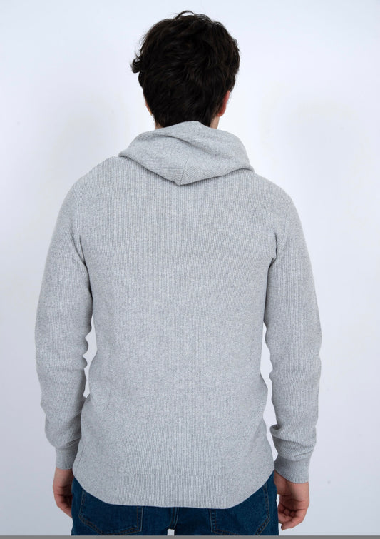 A person with dark hair, wearing HEDGE’s eco-friendly MENS HOODED SWEATER-OATMEAL MEL TWIST and blue jeans, stands with their back to the camera against a plain white background.