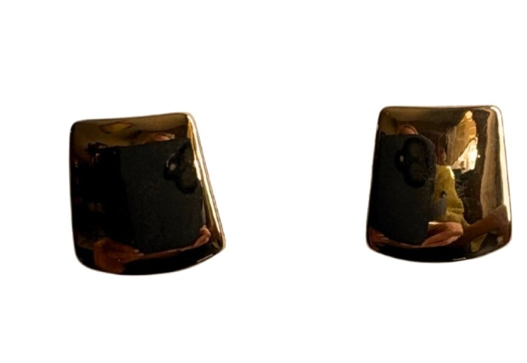 The Doris 14 Gold Clip-on Earrings by Elise accessories feature a shiny, rectangular design with slightly curved edges—perfect for those who appreciate classic gold costume jewellery.