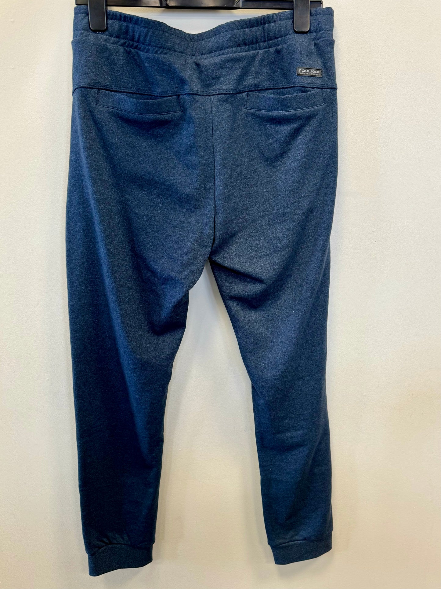 The Navy Sweatpants Ragwear - POCKE by RAGWEAR are a pair of jogger pants with an elastic drawstring waist, offering a comfortable fit. These vegan sweatpants feature side pockets and have ribbed cuffs at the ankles. The material is soft and provides remarkable comfort.