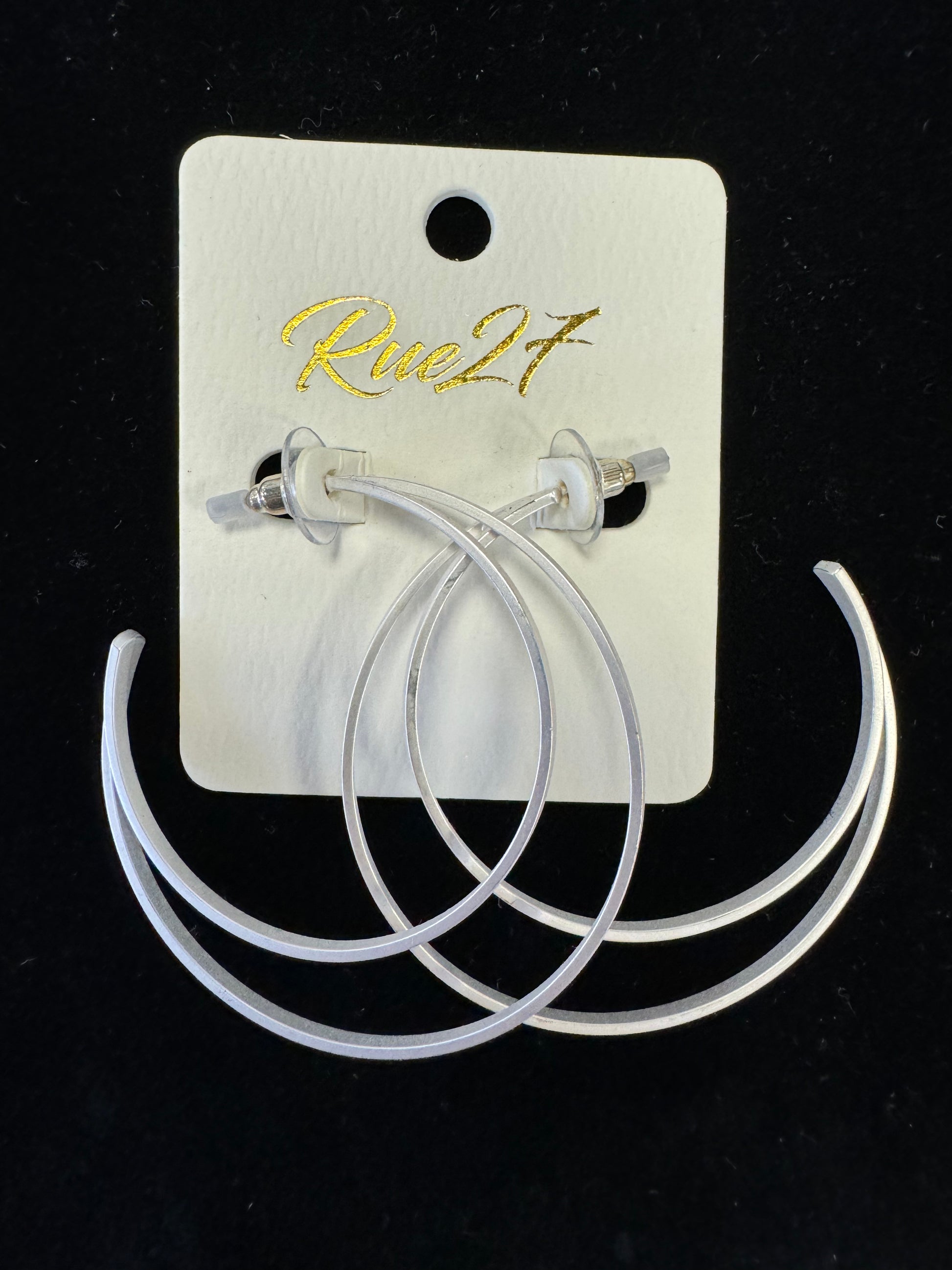 A pair of double-hoop Silver Moon Earrings is attached to a white backing card with the brand name "Posies Flowers & Fashion Inc." written in gold script. These elegant earrings are displayed against a black background, showcasing their exquisite silver color.