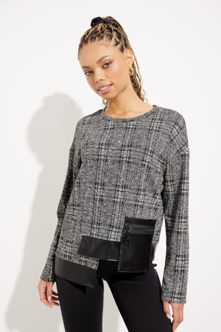 A woman with braided hair wears the black and multi-colored Checkered Faux Leather Top Style 233252 by Joseph Ribkoff, paired with black pants as she stands against a white background. She is slightly angled to one side, with a relaxed expression.