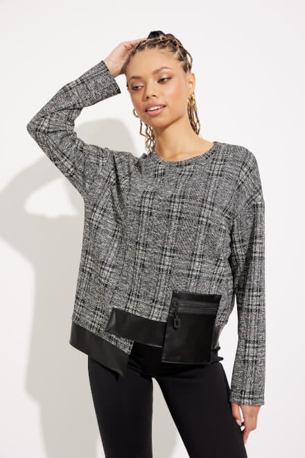 A woman with braided hair wears the black and multi-colored Checkered Faux Leather Top Style 233252 by Joseph Ribkoff, paired with black pants as she stands against a white background. She is slightly angled to one side, with a relaxed expression.