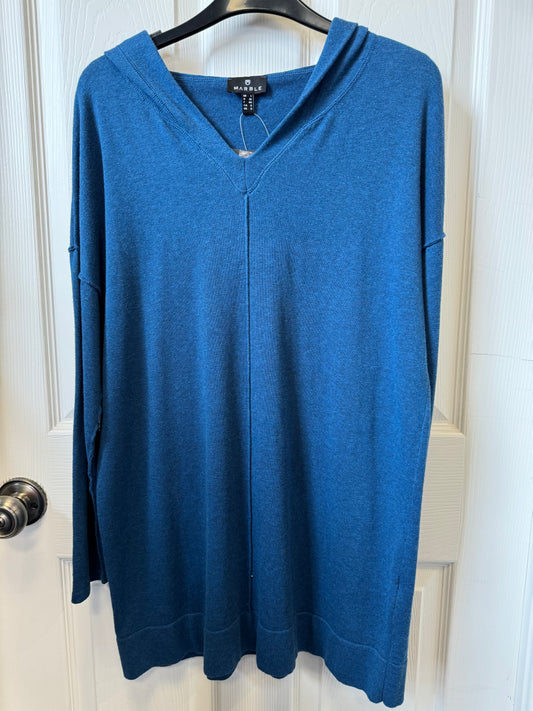 A blue knit hooded sweater, labeled "MARBLE," is hanging on a wooden hanger against a white paneled door. The hoodie features a V-neckline and appears to have a relaxed fit.