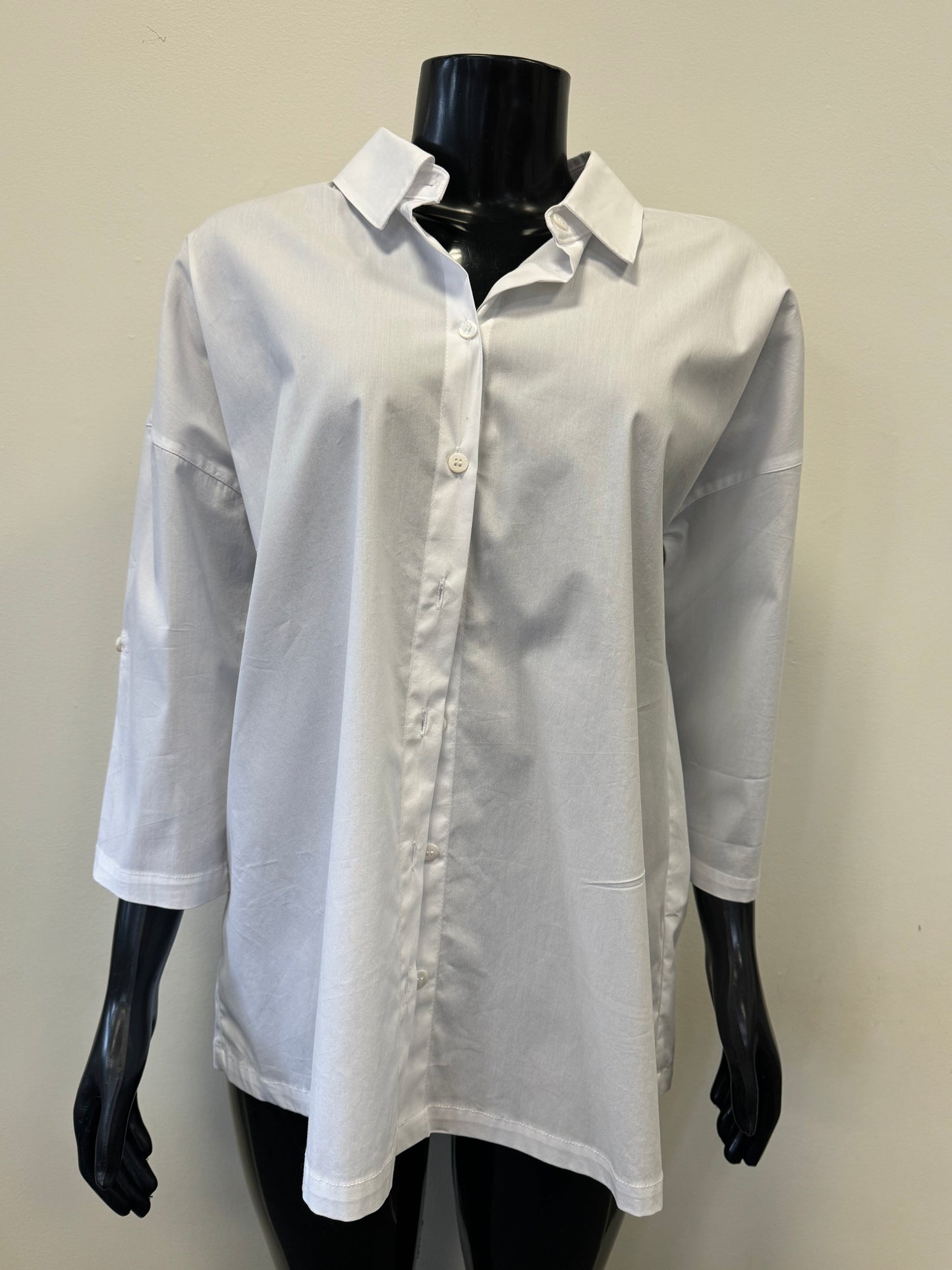 A plain white, long-sleeve FOIL Keeping Tabs Shirt (FO6936) from the FOIL brand is displayed on a black mannequin with a stand-up collar. The versatile shirt is unbuttoned at the top, featuring a relaxed fit and rolled sleeves, offering both comfort and a dressy look against a light-colored wall backdrop.