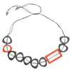 The Resin Rectangular Hoop Necklace by Suzie Blue is a modern accessory featuring a sleek rectangular hoop design with a thin grey cord and adjustable bead ends. It showcases black and orange angular geometric shapes, incorporating unique resin material, with one large rectangular orange piece and alternating black triangle-like figures, including one in orange.