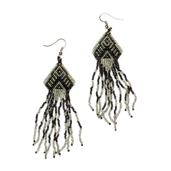 A pair of intricate, handmade Beaded Aztec Style Earrings - BLACK by Suzie Blue featuring a diamond-shaped design at the top. Black and gray beads create geometric patterns inspired by Aztec style, while several beaded strands dangle from each diamond shape, giving a flowing fringe effect. Ethically sourced from Bali.