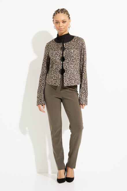 A person standing against a white background is dressed in an outfit featuring the Joseph Ribkoff Leopard Print Rounded Collar Jacket Style 233953, which boasts an earth-toned leopard motif, paired with a black turtleneck and olive-green pants. They are wearing black high-heeled shoes and have their hair styled in braids—an autumnal must-have look!