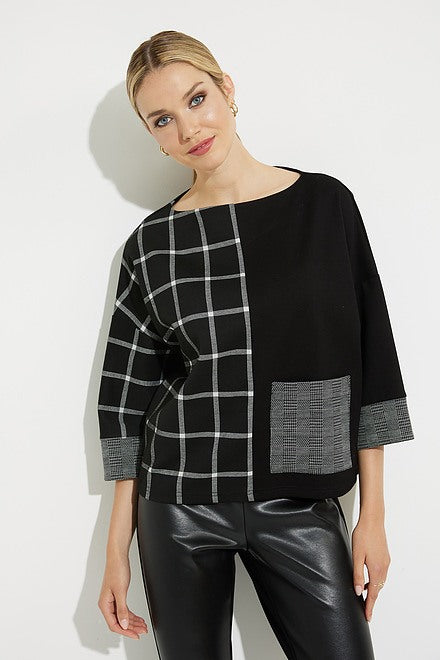 A woman stands against a white background wearing the Joseph Ribkoff Grid Print Top Style 224101, featuring a black and gray grid pattern on one side and a solid patch pocket. The top's relaxed fit complements her shiny black leather leggings and black heels. Her hair is tied back, and she smiles softly.