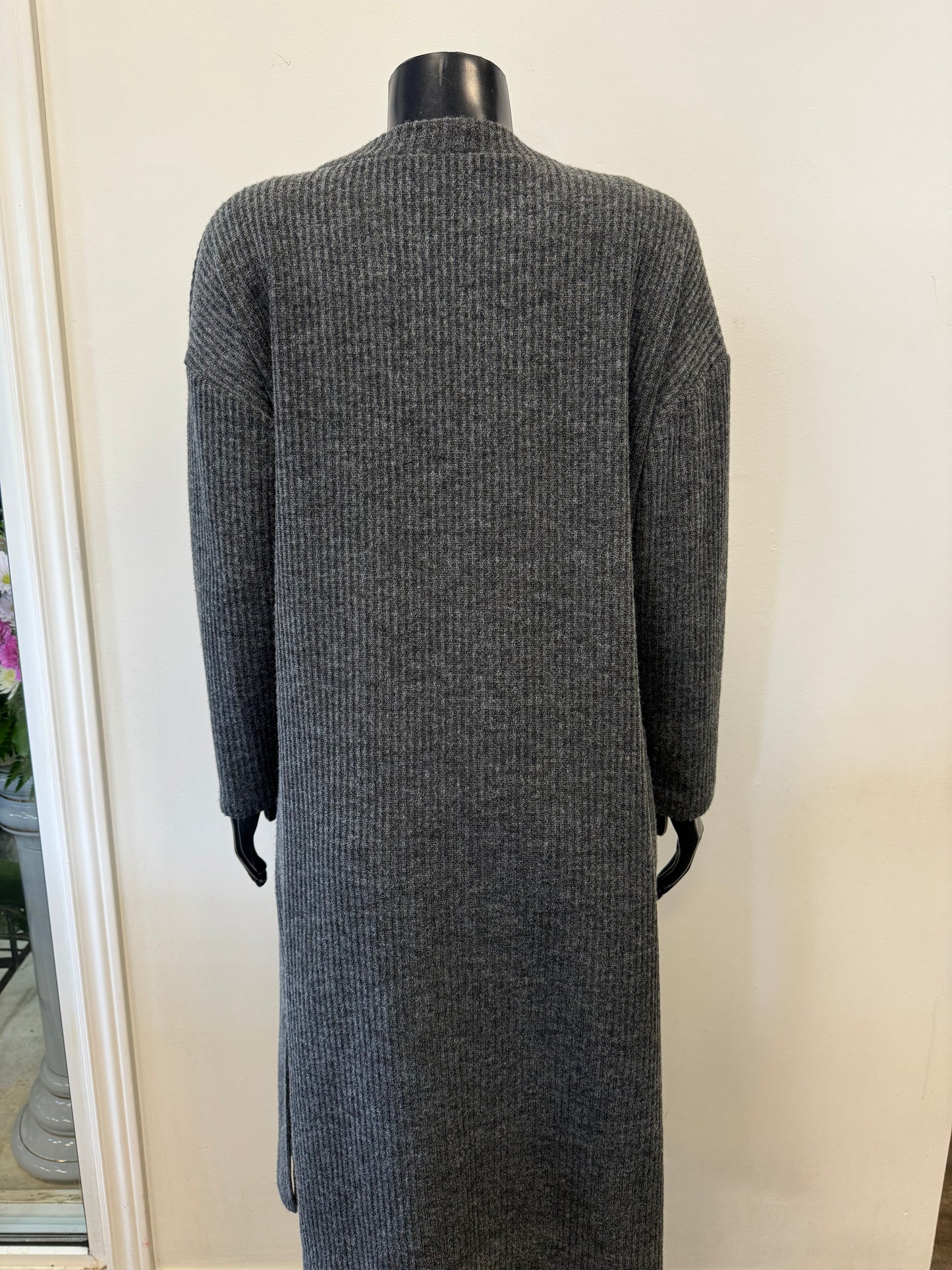 A mannequin dressed in Bali Corp's "Cardigan Grey Winter - Bali 7704" over a black top and black pants. The ribbed cardigan, made in Canada, features two front pockets and is displayed against a plain, light-colored background.