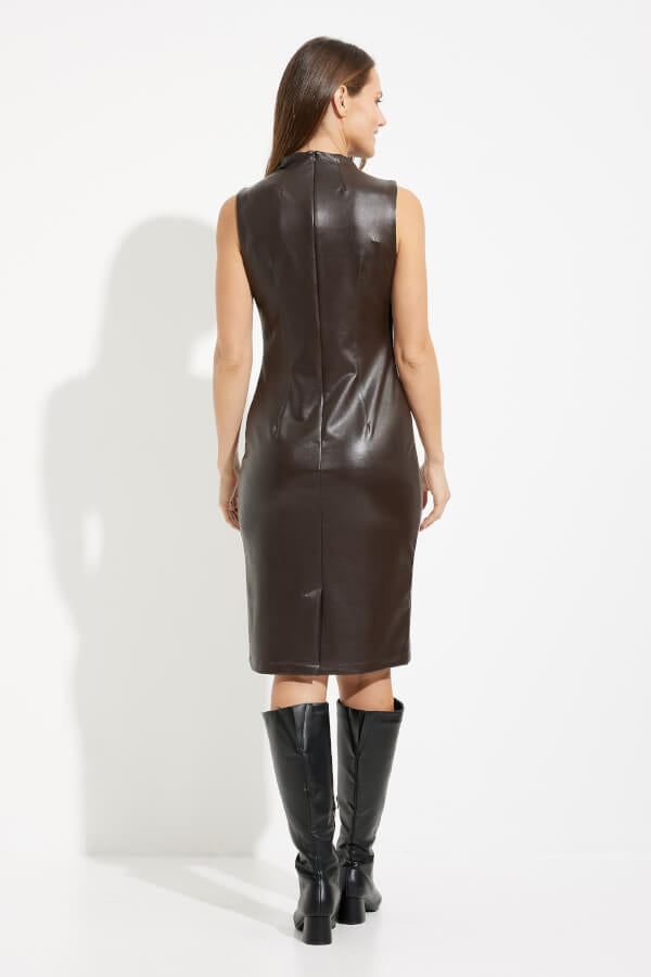 A woman is wearing a High Neck Faux Leather Dress Style 233010 by Joseph Ribkoff. The knee-length, figure-flattering dark brown vegan leather dress accentuates her silhouette. She stands against a plain white background, smiling slightly, with her left hand by her side and her right hand lightly touching her hip. Her long hair cascades in loose waves.