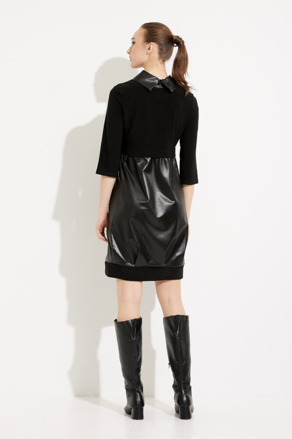 A woman stands against a white background wearing the Joseph Ribkoff Faux Leather Cocoon Dress Style 233091, a black empire waist dress with three-quarter sleeves and a shiny faux-leather material on the lower portion. She pairs the dress with knee-high black boots and has her hair styled in a neat updo.