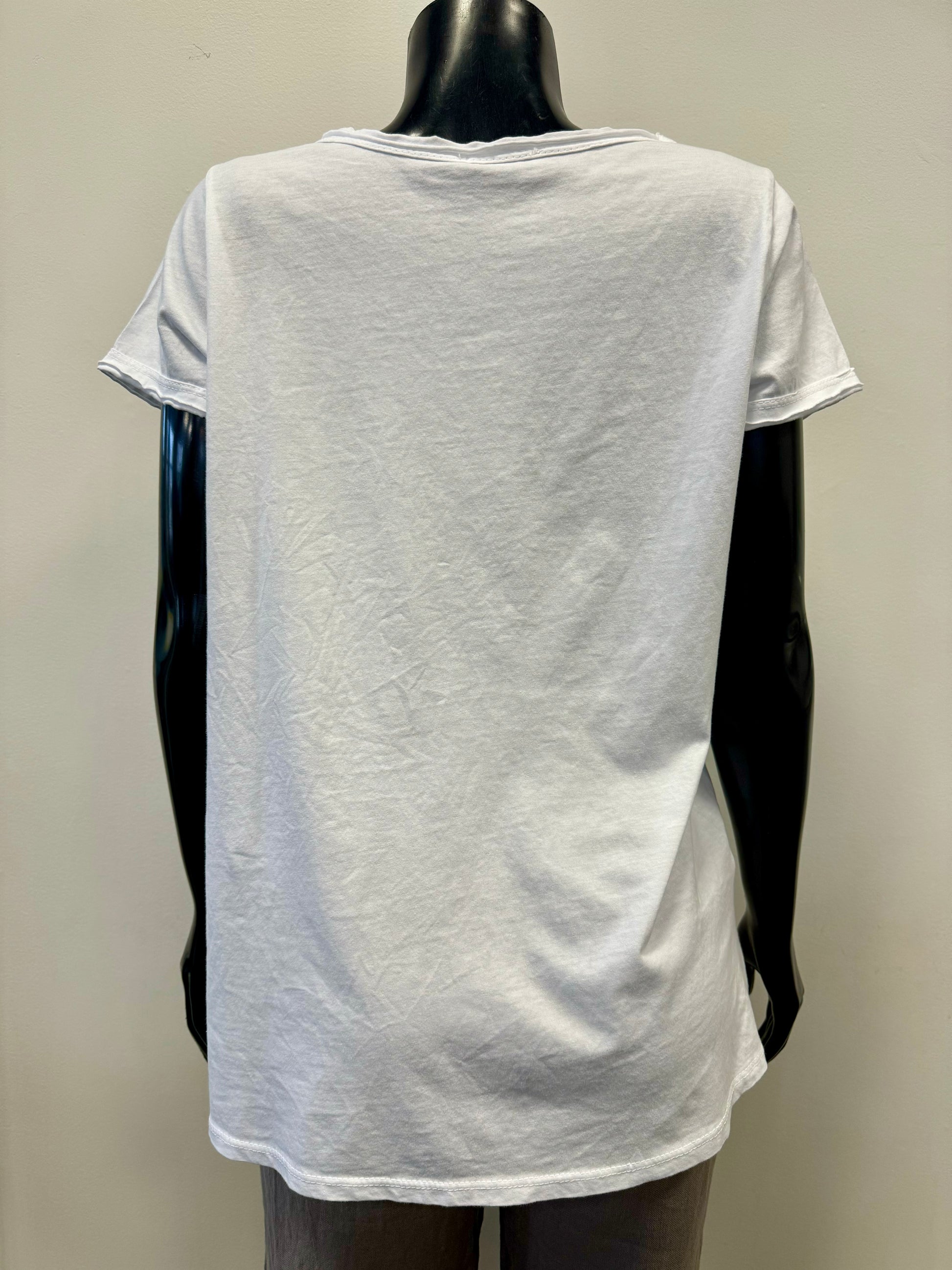 A black mannequin is adorned in an elegant Femme Fatale Blue Paintstroke Tee (FEMME FATALE T-32TEE) featuring a white V-neck and blue, horizontally striped abstract pattern on the front. Complemented by beige pants, this outfit exudes Italian elegance against the backdrop of a plain light-colored wall.