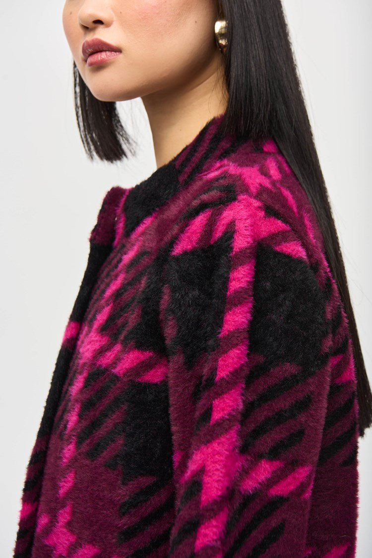 A woman with straight black hair and bangs stands against a plain background. She is wearing the stylish Feather Yarn Jacquard Plaid Jacket 243931 by Joseph Ribkoff, featuring a bold magenta and black checkered pattern. She has a neutral expression, and her arms are relaxed at her sides.