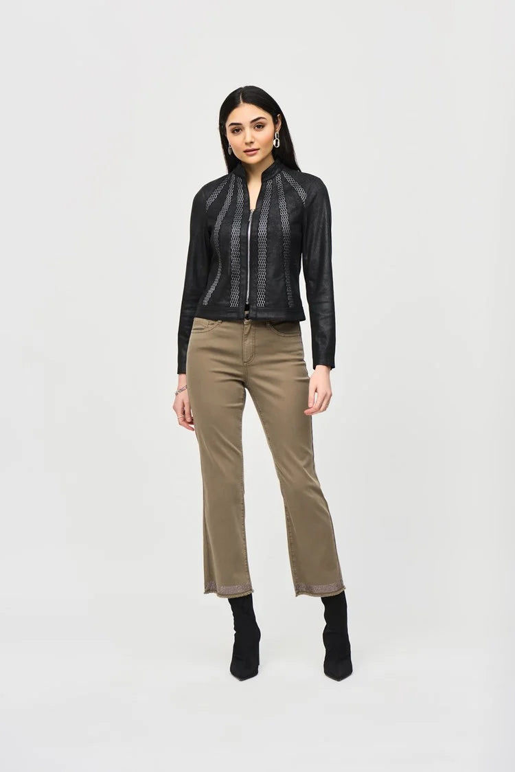 A woman stands against a plain white background, wearing the Joseph Ribkoff Faux Suede Jacket With Metallic Mesh Detail 243972. She pairs it with khaki straight-leg pants that are slightly cropped and black heeled ankle boots. Her long, dark hair cascades down, and she accessorizes with statement earrings.