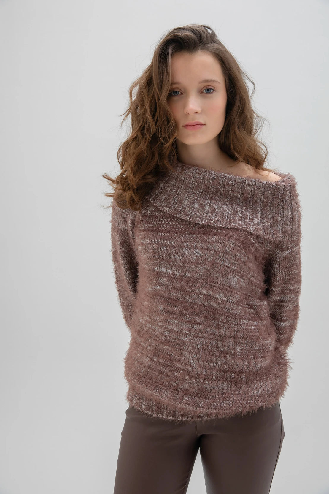 A woman with long, wavy brown hair is wearing a fashionable and cozy Sweater 7544 MARBLE by MARBLE. The fuzzy brown sweater features a stylish cowl neck. She is standing against a plain white background and looking forward with a neutral expression.