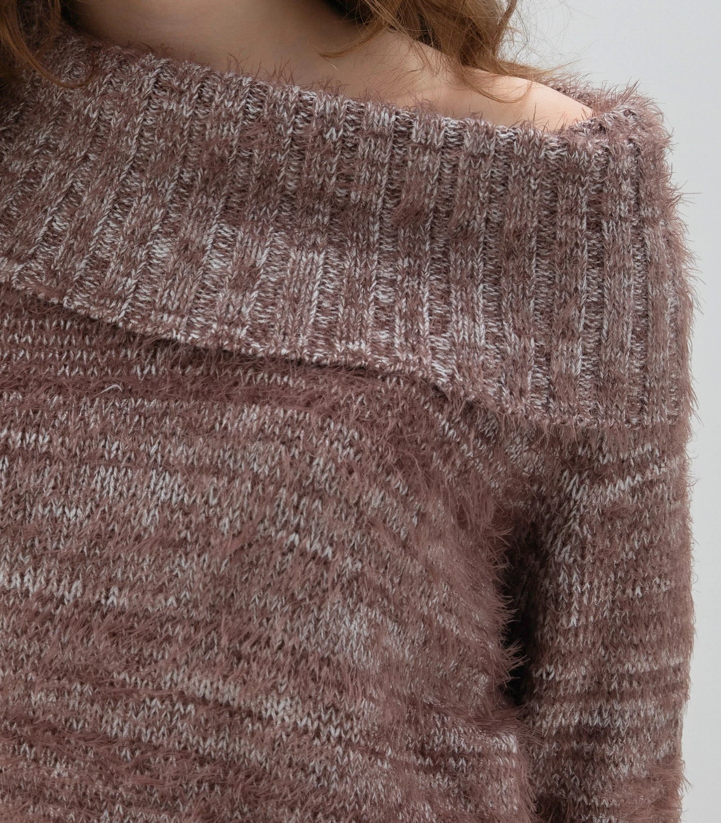 A woman with long, wavy brown hair is wearing a fashionable and cozy Sweater 7544 MARBLE by MARBLE. The fuzzy brown sweater features a stylish cowl neck. She is standing against a plain white background and looking forward with a neutral expression.