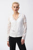 A person with short blonde hair wears the stylish Novelty Knit Straight Fit Jacket 251215 by Joseph Ribkoff, featuring a white mesh design with a front zipper closure over a black top. They stand confidently against a plain white background.