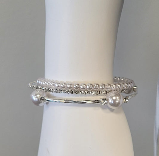 A white mannequin wrist displays the Mimosa 20 Bracelet by Elise accessories, featuring lustrous pearls, sparkling rhinestones, and a thin silver bangle accented with large pearl beads and rhinestones.