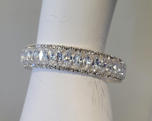 The Mimosa 15 Bracelet by Elise Accessories features marquise-cut clear gemstones on memory wire, bordered by smaller round stones, and is shown on a white holder.