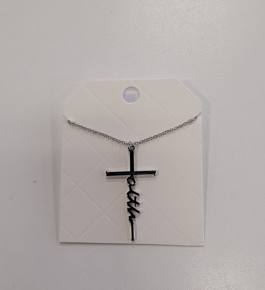The Trina 13 Necklace by Elise accessories features "faith" woven into a silver cross, displayed on a diamond-patterned white card—a stylish addition to any collection.