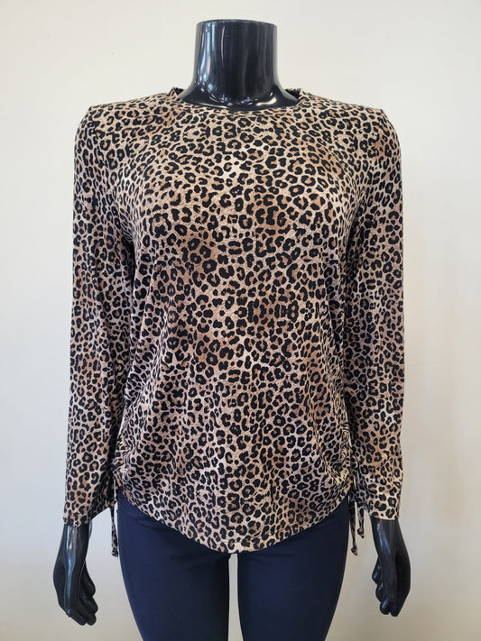 A mannequin displays the Bali Corp Leopard Print Top featuring long sleeves and side drawstrings, styled with dark pants against a plain light background.