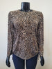 A mannequin displays the Bali Corp Leopard Print Top featuring long sleeves and side drawstrings, styled with dark pants against a plain light background.