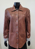 The Stevie CF Leather Jacket by MAURITIUS LEATHER, in brown cognac leather with a collar, button-down front, and large front pockets, is displayed on a black mannequin against a plain light background.
