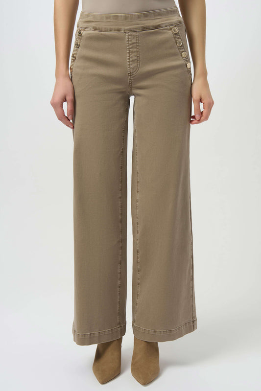 A person wearing Joseph Ribkoff Classic Wide Leg Pull-On Jeans 254919, featuring button-detailed pockets, styled with tan pointed-toe shoes. Image is cropped from the shoulders down.