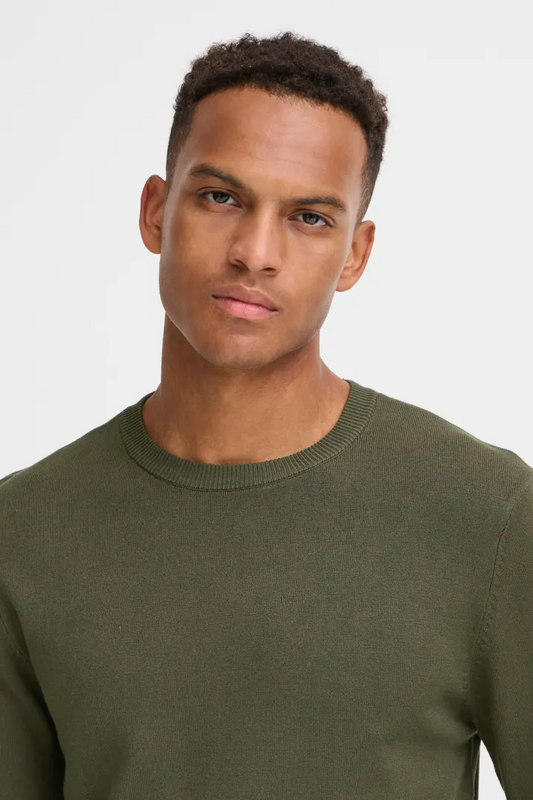 A young man with short curly hair wears the RAGWEAR Knitted Pullover 20718853 blend in olive green, looking directly at the camera with a neutral expression against a plain light background.