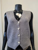 The ETERNELLE Button Up Knit Vest -eternelle is a sleeveless, light grey knit vest with four white front buttons, shown on a black mannequin against a plain background—a classic addition to any wardrobe.