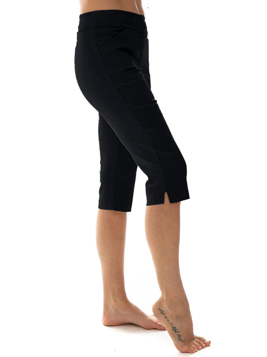A person wearing the Bali Corp Bali Capri 7246 in black stands barefoot on one foot with the other leg slightly bent, set against a white background.