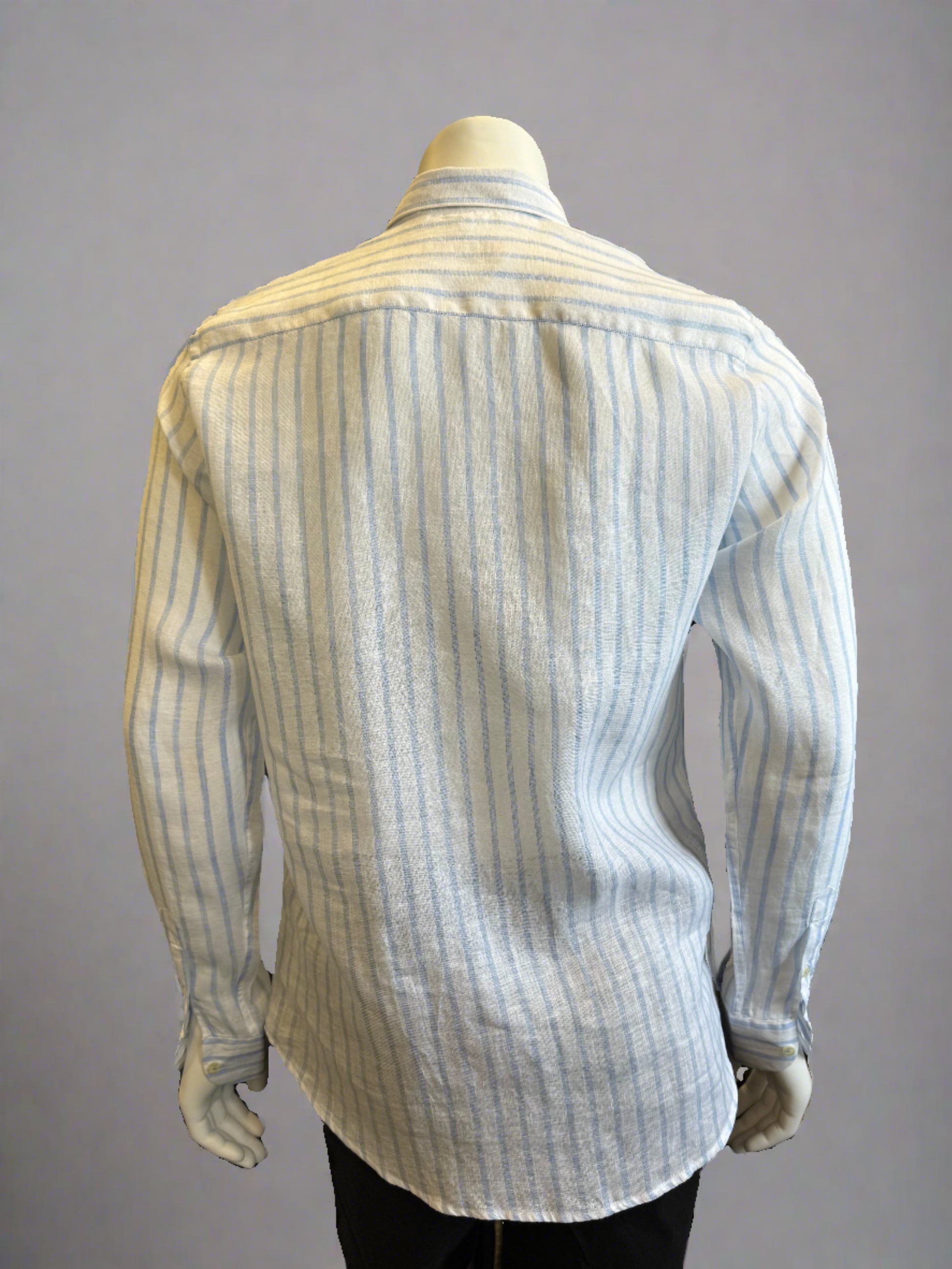 A mannequin dressed in a Paul Miranda Linen Shirt Striped Cielo, made from 100% linen and featuring vertical blue and white stripes. This long-sleeved, button-up shirt with a collar is crafted in Italy and paired with black pants. The background is a plain light grey.