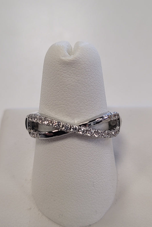 The JENNA-63 Adjustable Ring by Elise accessories is a white gold or platinum infinity stretch ring with embedded small diamonds, displayed on a white ring holder against a plain background.