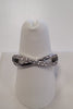 The JENNA-63 Adjustable Ring by Elise accessories is a white gold or platinum infinity stretch ring with embedded small diamonds, displayed on a white ring holder against a plain background.