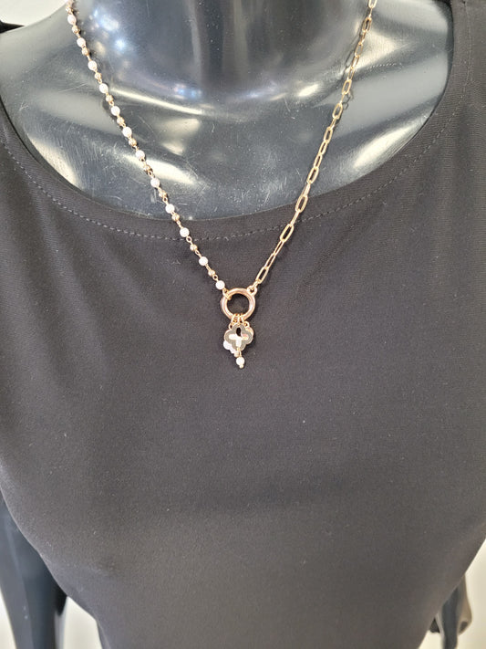 A mannequin in a plain black top showcases the Elena Necklace from Elise accessories, featuring a gold chain and a pendant with a delicate flower and pearl-like detail.