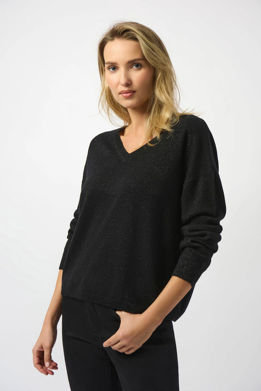 A person with shoulder-length blonde hair wears the Joseph Ribkoff Wool Blend V-Neck Boxy Sweater 253967 and black pants, standing against a plain white background and looking at the camera with a neutral expression.