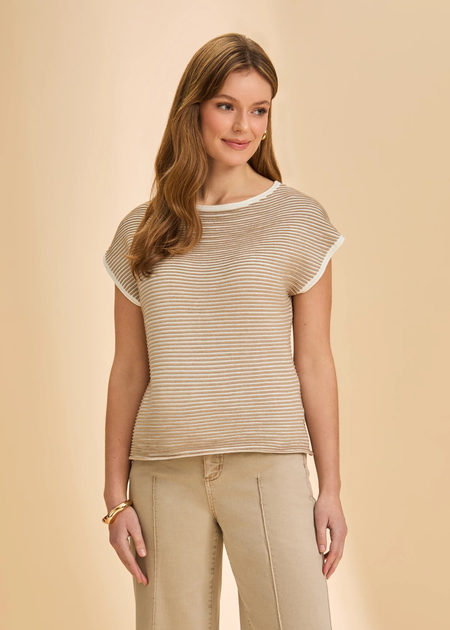 A woman with long, light brown hair smiles softly in the French Dressing Jeans Boatneck Cap Sleeve Sweater in Light Henna, styled against a plain beige background.
