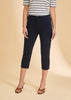 Wearing a striped short-sleeve shirt, French Dressing Jeans Suzanne Capri in navy, and brown open-toe heeled sandals, the person stands against a beige background with their face not visible.