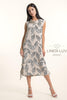 A woman models the French Linen Dress TP1676P-11 Sabbia by LinenLuv, a sleeveless beige dress with a black botanical print, paired with white heels. "LINEN LUV" is displayed to the right.
