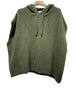The 1622A PONCHO FALL WINTER: KAKI by LINEN & COTTON HOUSE is an olive green knitted sleeveless hoodie, inspired by the elegance of an Italian poncho, displayed on a wooden hanger against a white background—perfect as a cozy wrap for fall and winter.